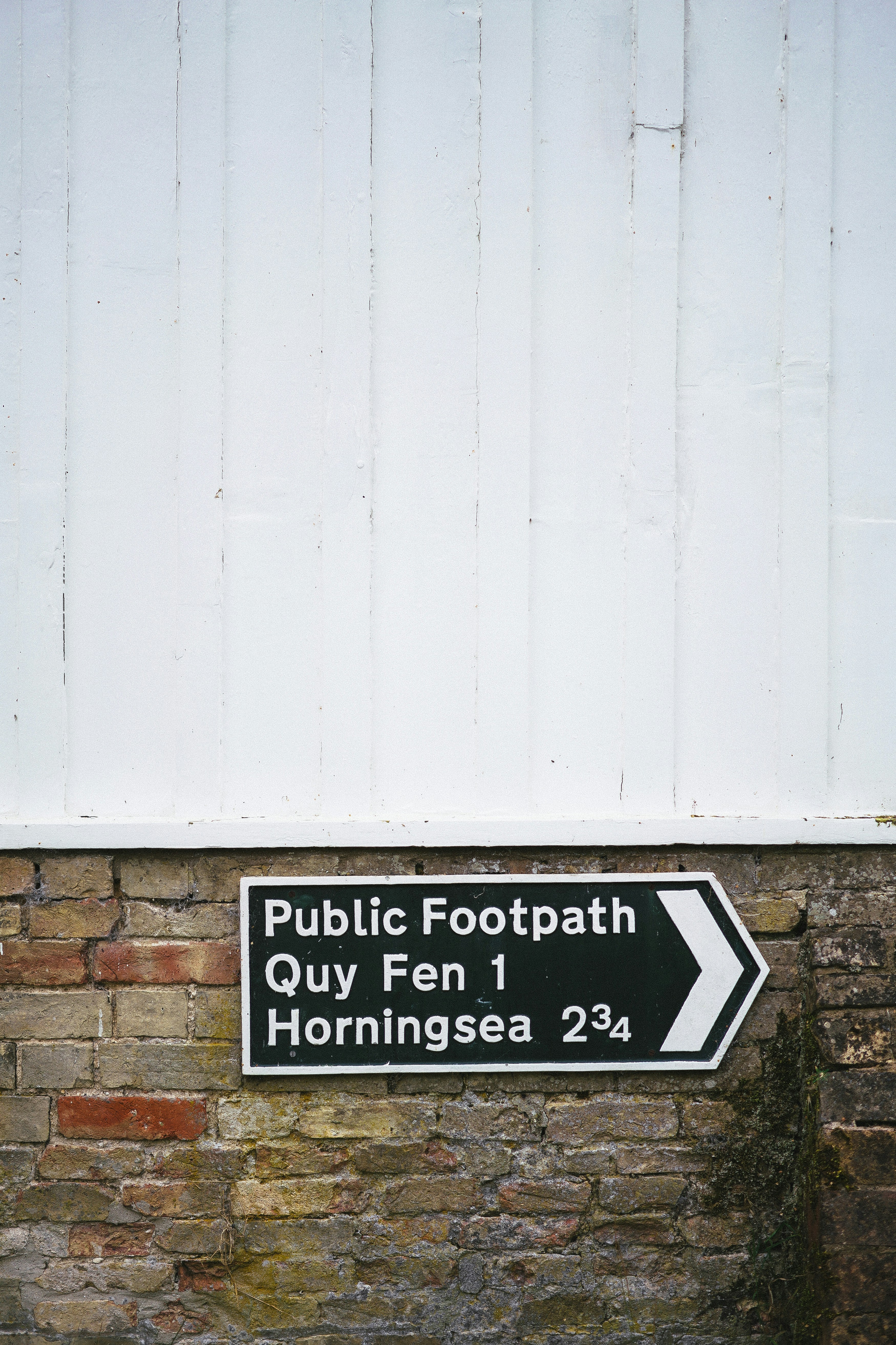 A black and white sign on a brick wall